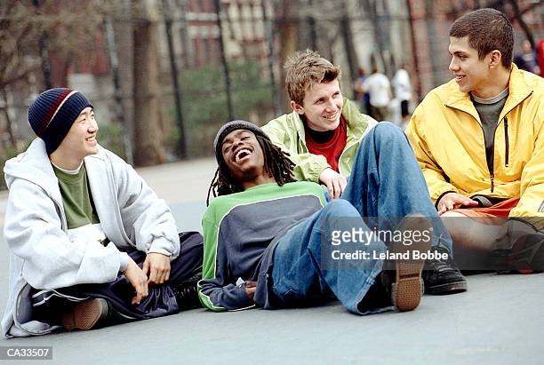 four  teenage boys (15-17) laughing in city playground - leland bobbe foto e immagini stock