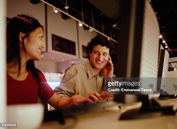 young couple flirting in internet cafi - emmanuel stock pictures, royalty-free photos & images