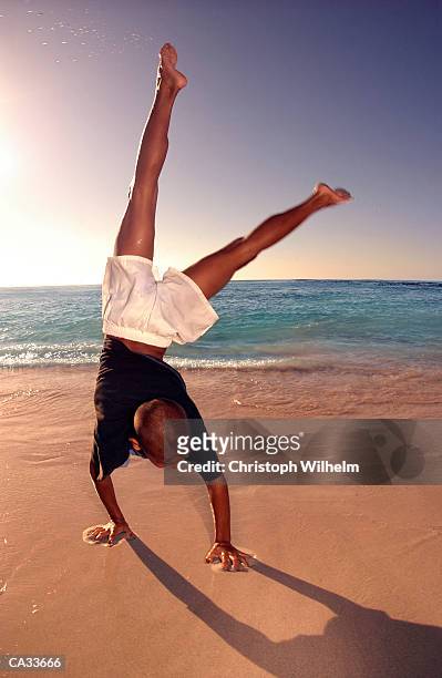boy (12-14) doing handstand on beach - cape province stock pictures, royalty-free photos & images