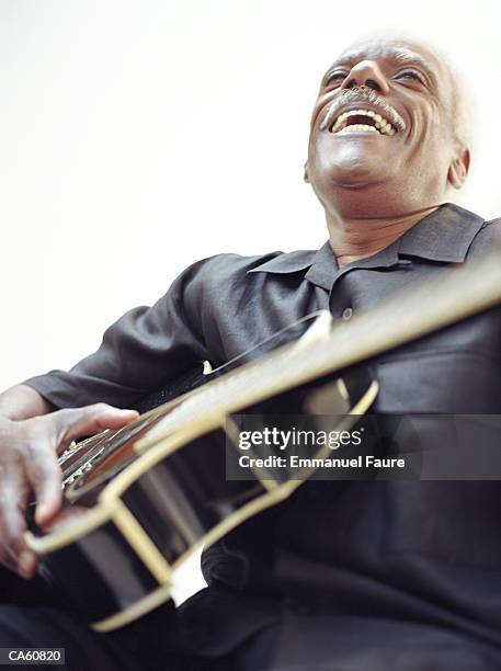 mature man holding guitar and laughing - acoustic guitar white background stock pictures, royalty-free photos & images