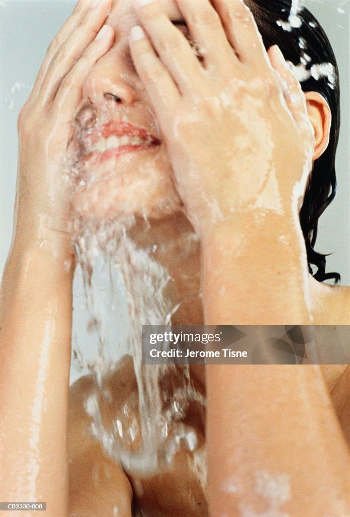 Young woman splashing water over face, close-up
