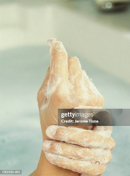woman soaping hands in bath, close-up - hand rubbing stockfoto's en -beelden