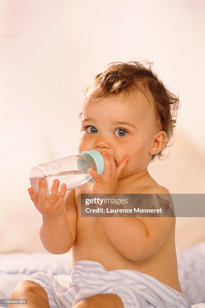Baby girl (12-15 months) drinking from baby bottle, portrait