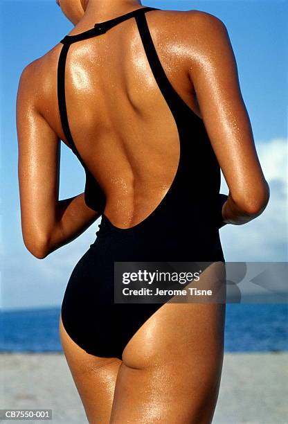 tanned young woman wearing swimming costume, rear view, close-up - swimsuit stock-fotos und bilder