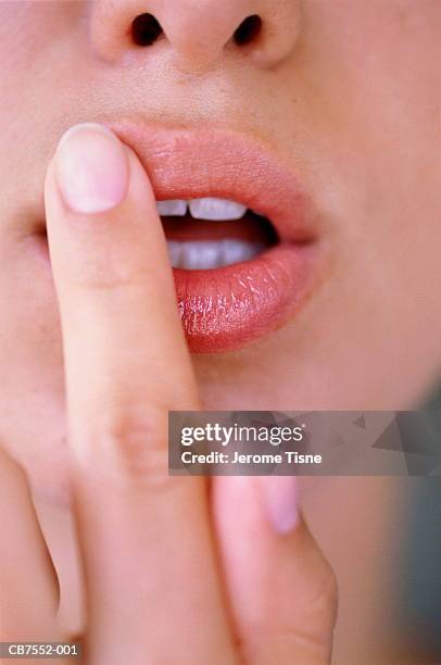 young woman's finger touching lips, close-up - labios fotografías e imágenes de stock