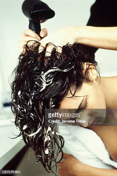 hairdresser's hands styling and blow-drying young woman's hair - mousse foto e immagini stock