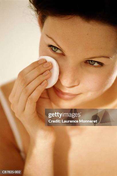 young woman using cotton wool to wipe face, close-up - cotton pad stock pictures, royalty-free photos & images