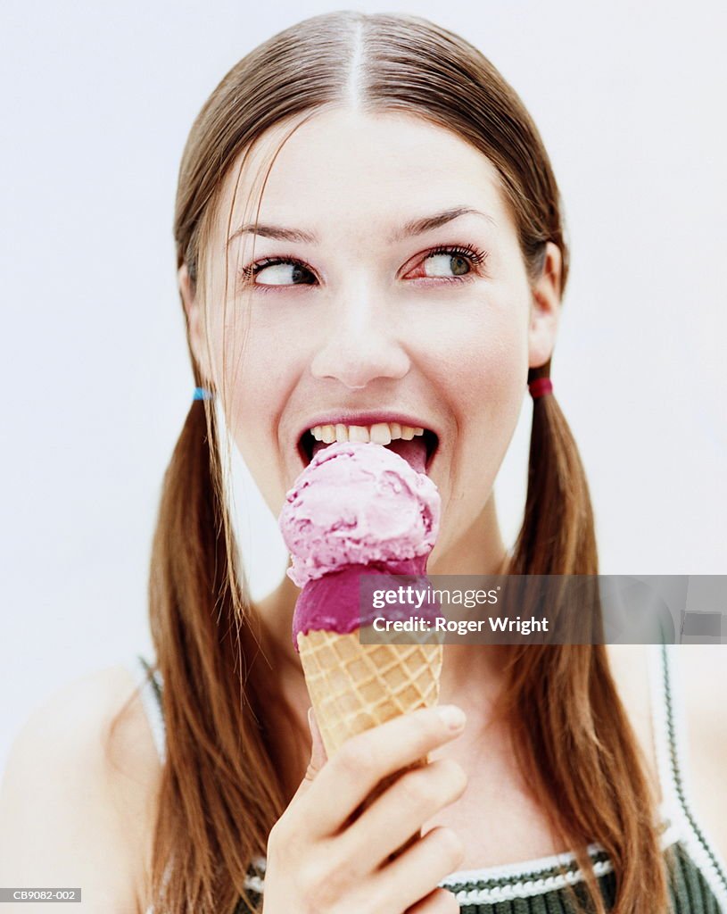 Young woman eating ice-cream, close-up, portrait