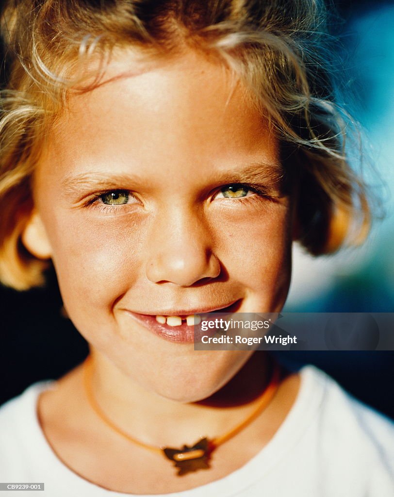 Girl (8-10) outdoors, smiling, close-up, portrait