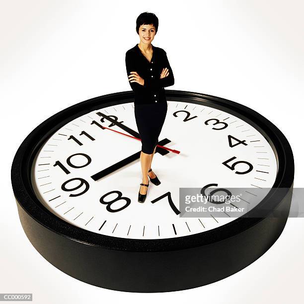 businesswoman standing on a clock - wall clock 個照片及圖片檔