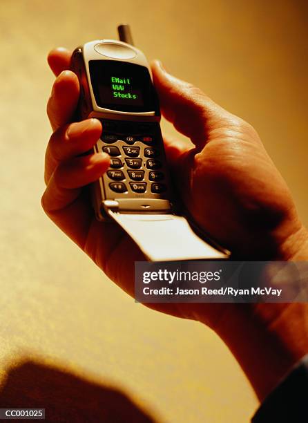 close-up of a man holding a cellular phone - wap foto e immagini stock