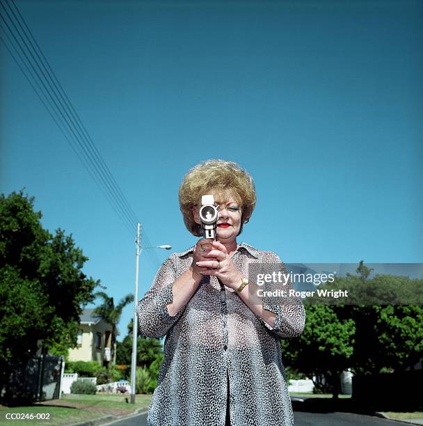 mature woman using video camera outdoors, close-up - entrometido fotografías e imágenes de stock