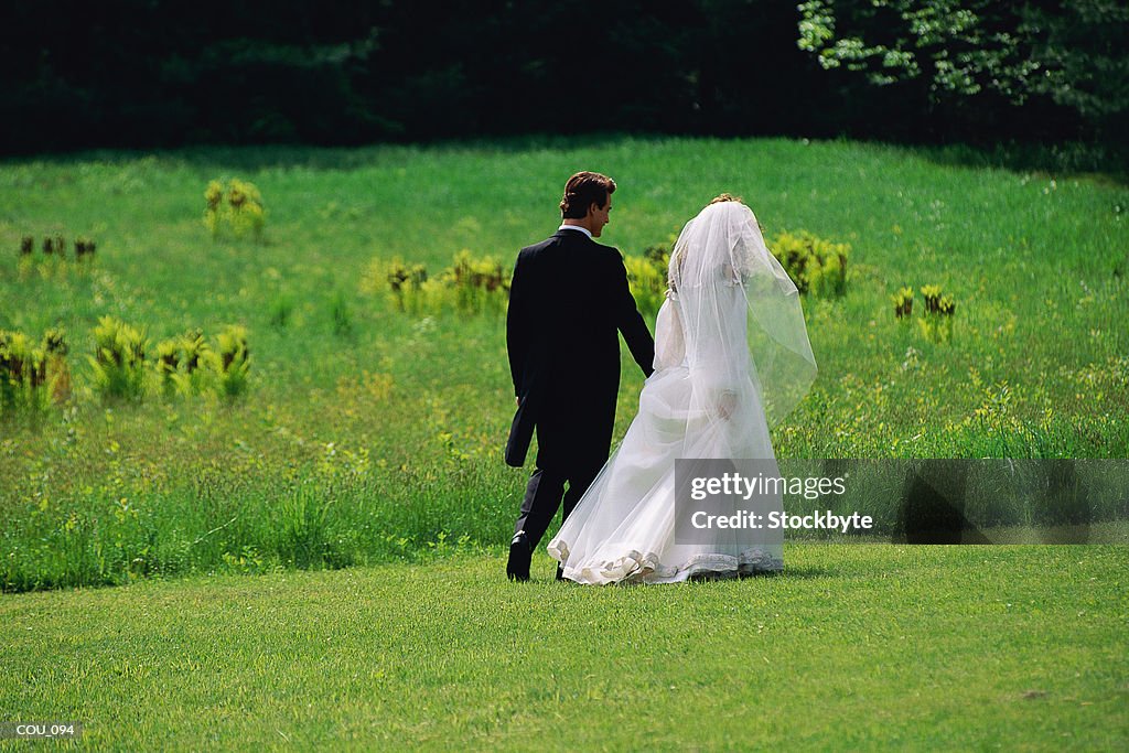 Man and woman walking  wearing wedding attire