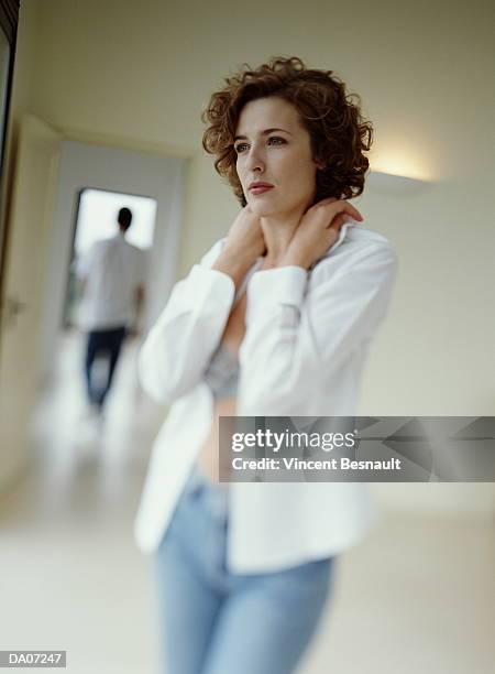 young woman wearing open blouse, man in background (focus on woman) - open blouse stock-fotos und bilder