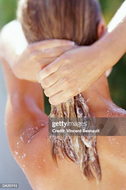 woman shampooing hair, close-up, rear view - shampoo stockfoto's en -beelden