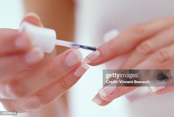 young woman painting fingernails, close-up - get manicure stock-fotos und bilder