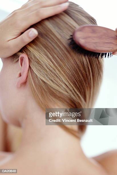 young woman brushing hair, close-up, rear view - woman brushing hair stockfoto's en -beelden