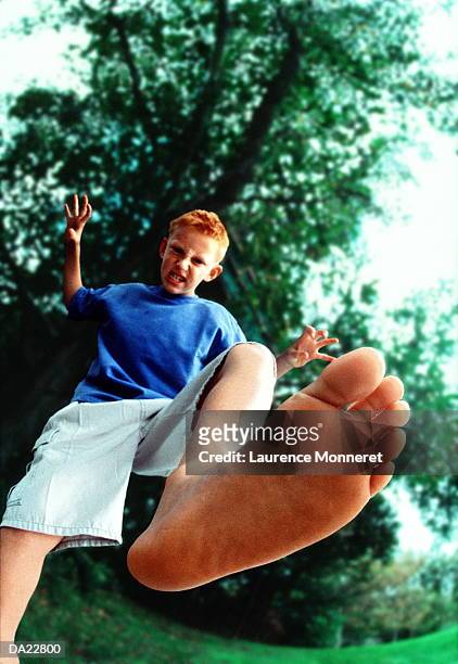 boy (7-9) stamping foot, low angle view (focus on foot) - stampen stockfoto's en -beelden