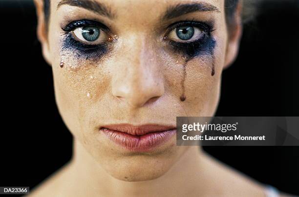 young woman wearing black eye make-up, crying, close-up - teardrop stock-fotos und bilder