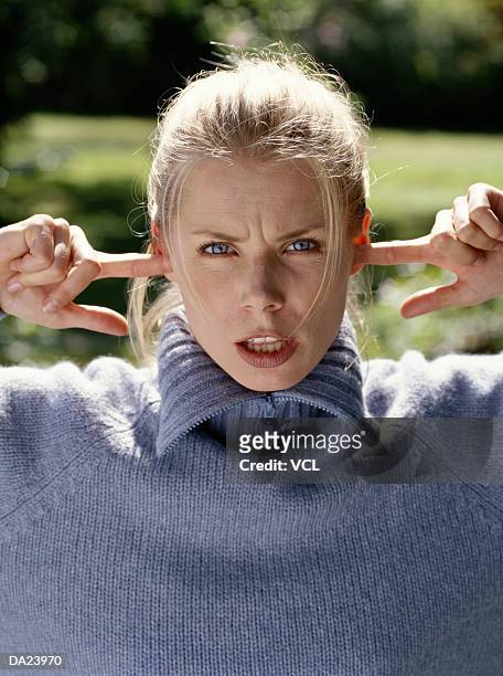 woman with fingers in ears, portrait - woman fingers in ears stock pictures, royalty-free photos & images