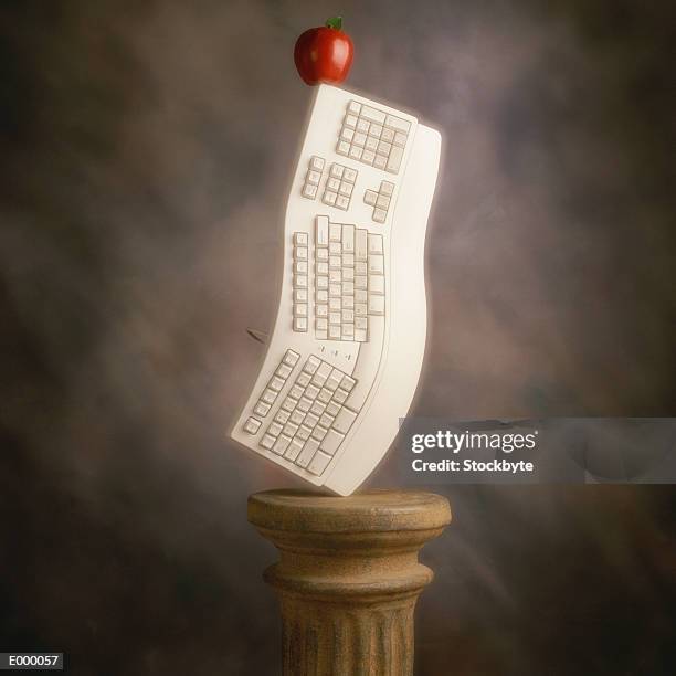 egrgonomic keyboard standing on end, apple balancing on top - ergonomic keyboard stock pictures, royalty-free photos & images