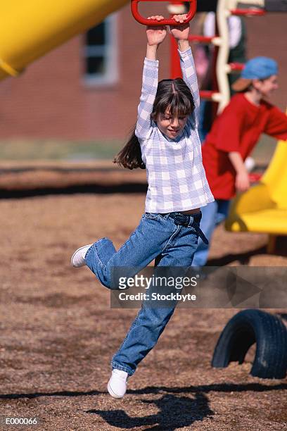 girl playing on playground, hanging from jungle gym - jungle gym ストックフォトと画像
