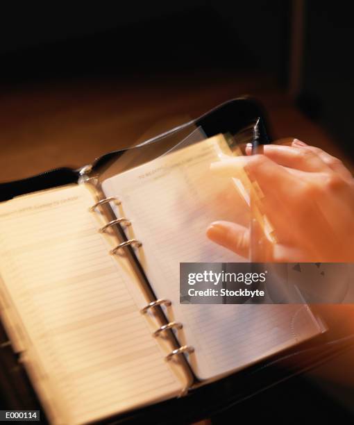 hand holding pen and turning pages of personal organizer - pages of president george washingtons first inaugural address on in u s capitol building stockfoto's en -beelden