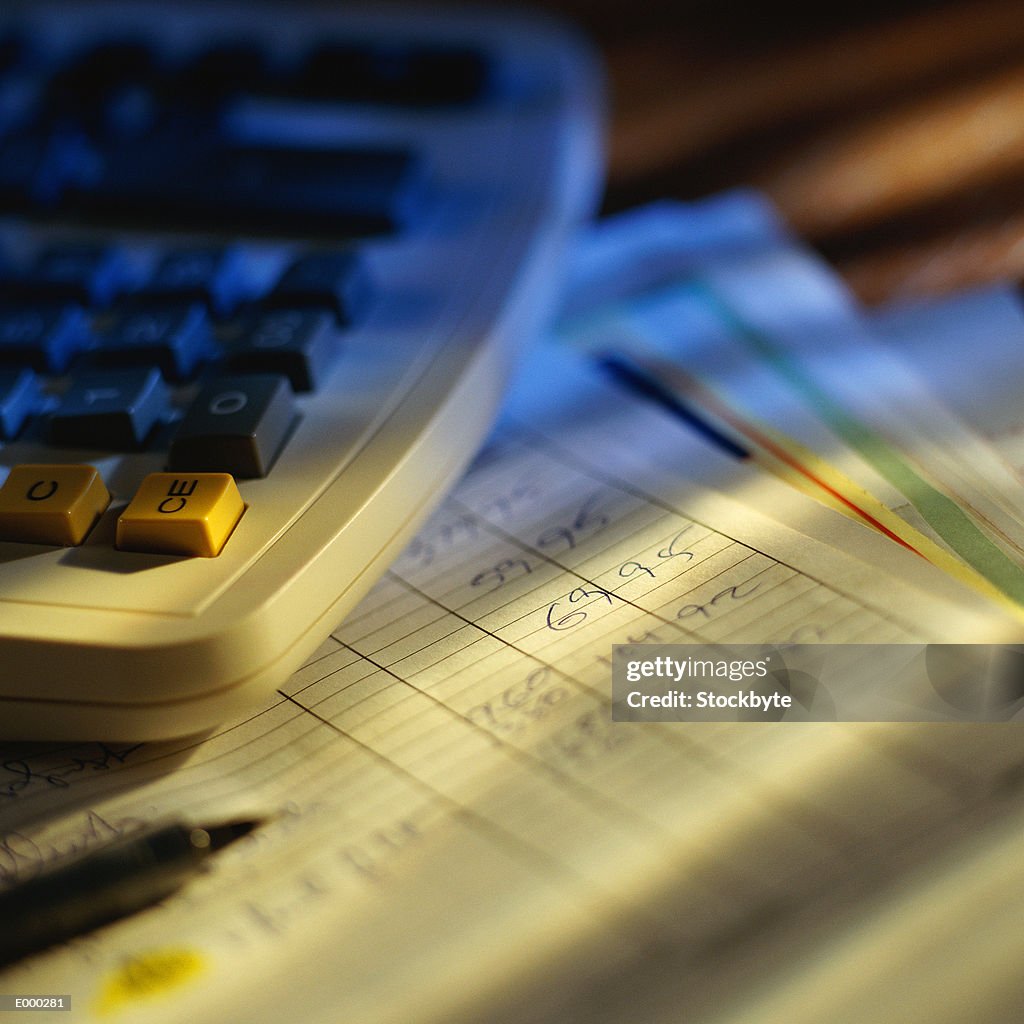 Calculator and pencil on top of balance sheet