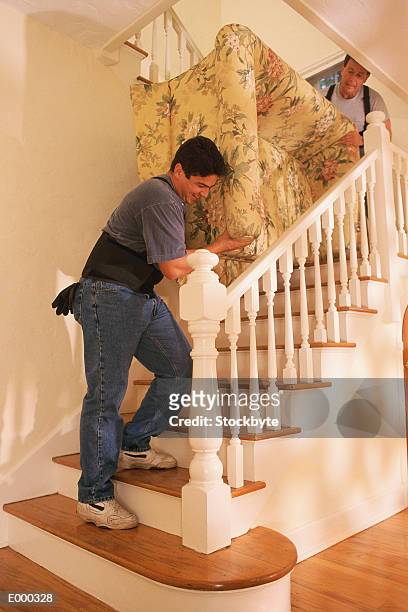 two men carrying couch up stairs - tweezits bankje stockfoto's en -beelden