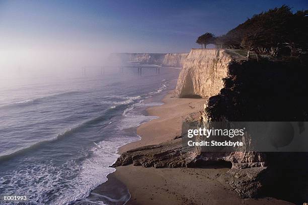 surf rolling in on beach with cliffs - davenport stock pictures, royalty-free photos & images