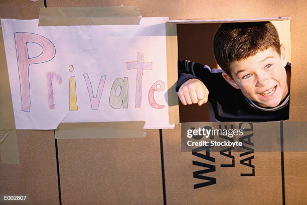 boy in cardboard house, peeking head out of window - restricted area sign stock pictures, royalty-free photos & images