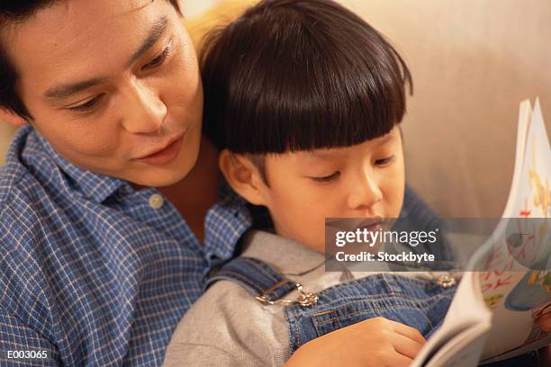 father reading with son - bedtime stories stock-fotos und bilder