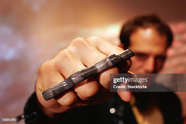 closeup of man's hand with brass knuckles - knuckle duster imagens e fotografias de stock