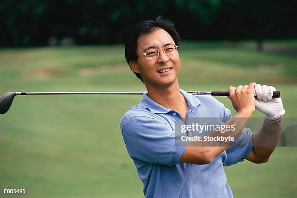 golfer during follow through from swing - follow through stock pictures, royalty-free photos & images