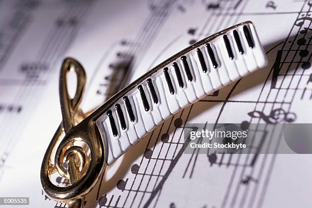 close-up of a musical pin over sheet music - pin up fotografías e imágenes de stock