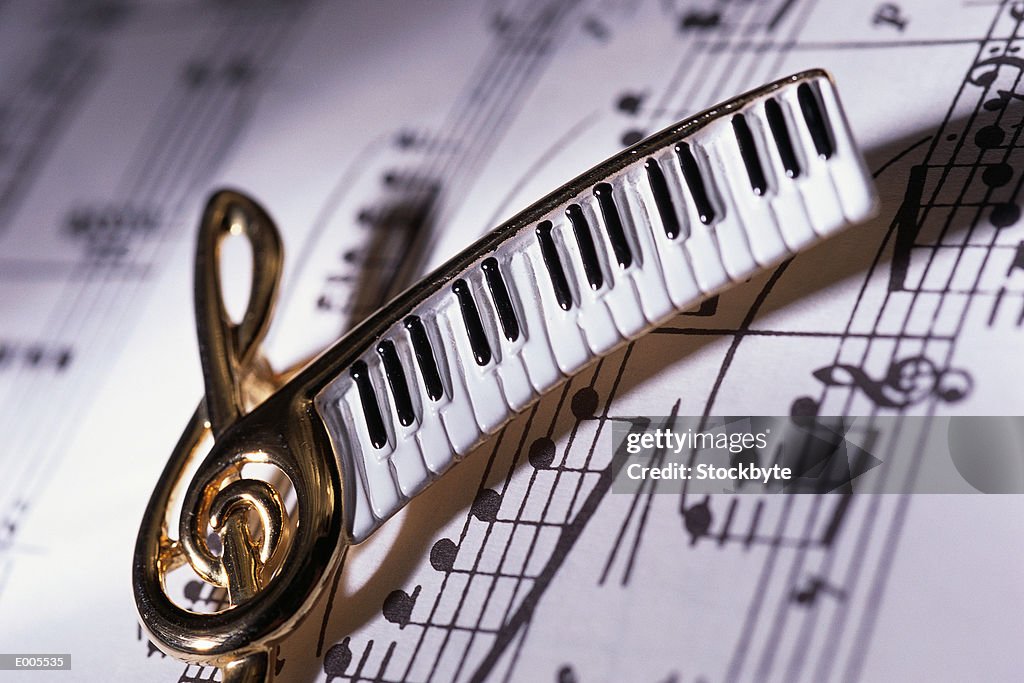 Close-up of a musical pin over sheet music