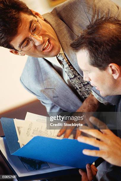 man showing papers to another man - commercial event 個照片及圖片檔