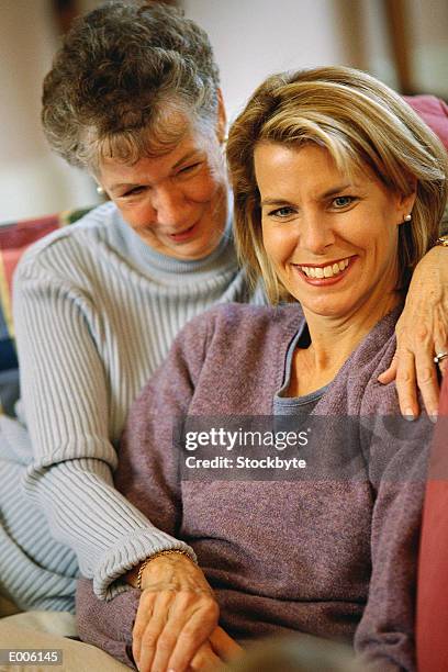 older woman holding younger woman - older woman younger man stock-fotos und bilder