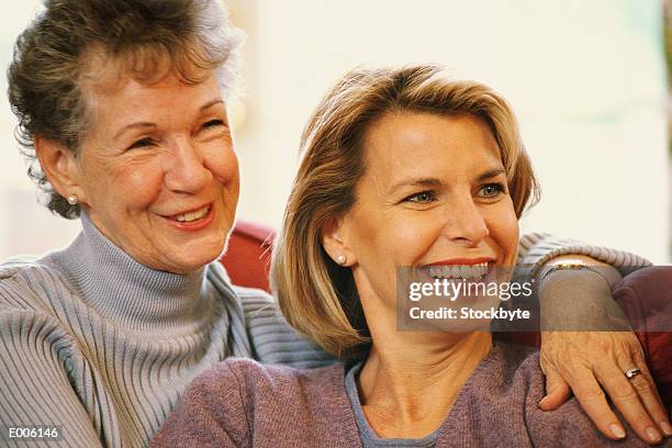 older and younger woman sitting together - older woman younger man stock-fotos und bilder