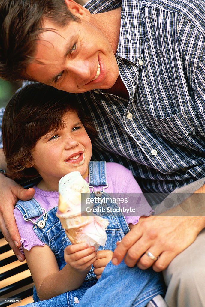 Father leaning over girl with ice cream