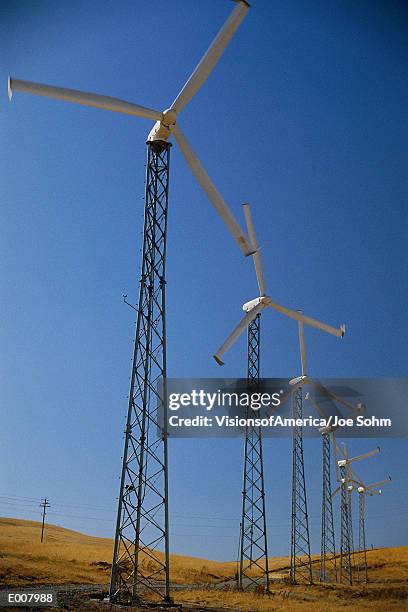 row of horizontal-axis wind turbines standing on ground - altamont pass stock pictures, royalty-free photos & images