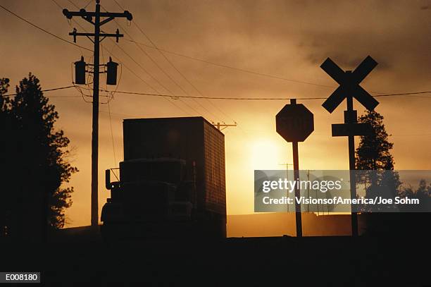 usa, idaho, coeur d'alene, semi-truck at railroad crossing, sunset - coeur fotografías e imágenes de stock