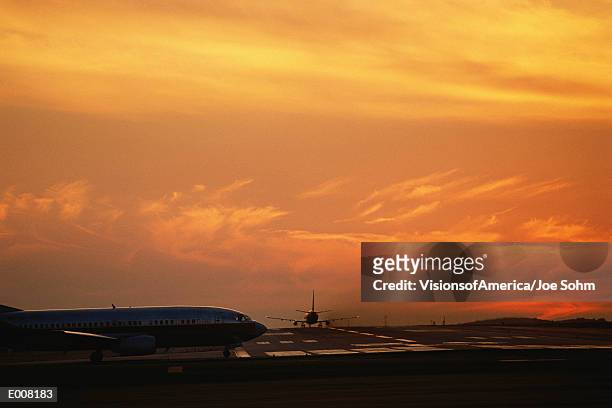 airplanes on runway at sunset - taxiing stock pictures, royalty-free photos & images