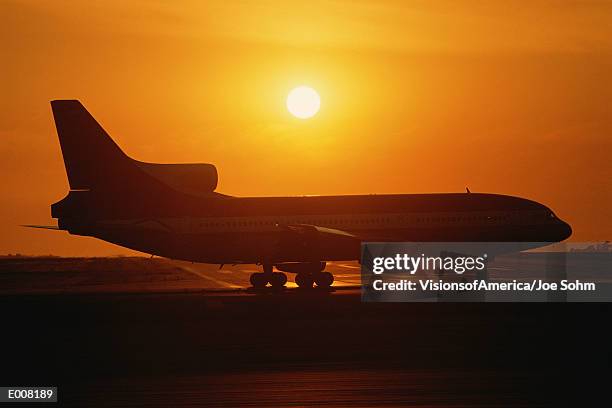 jet airplane on tarmac at sunset - taxiing stock pictures, royalty-free photos & images