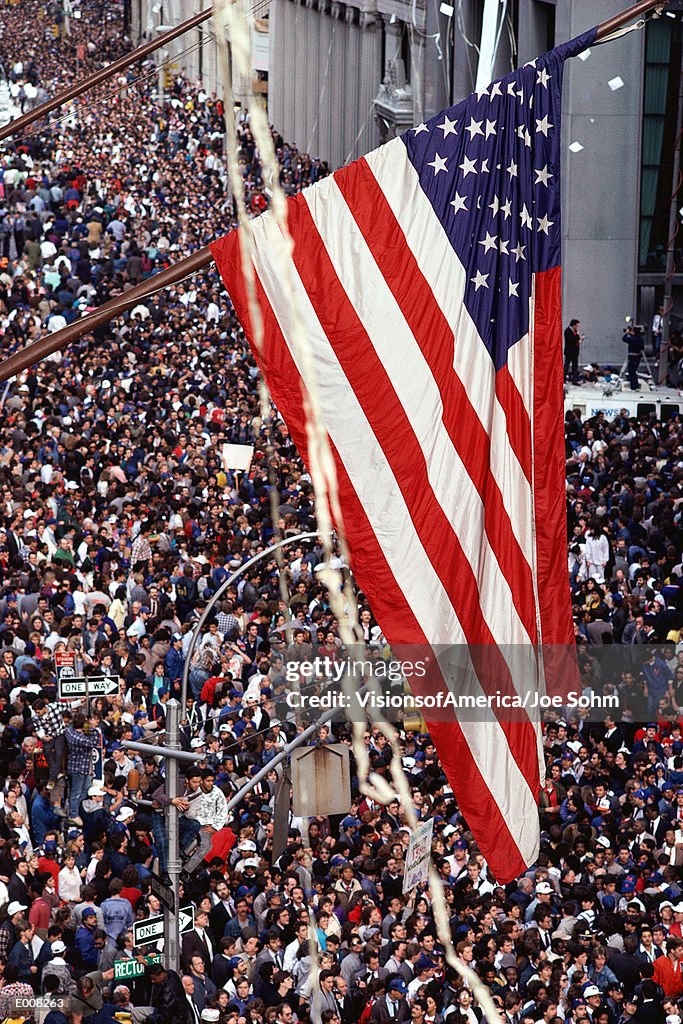 American flag hanging over crowd at ticker tape parade