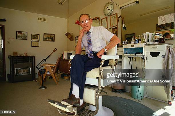senior citizen gentleman sitting in barber's chair - citizen stock-fotos und bilder