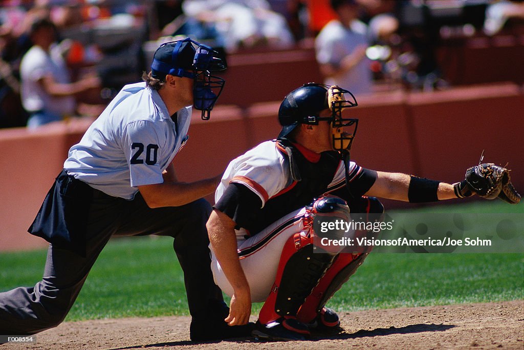 Baseball catcher and umpire at game