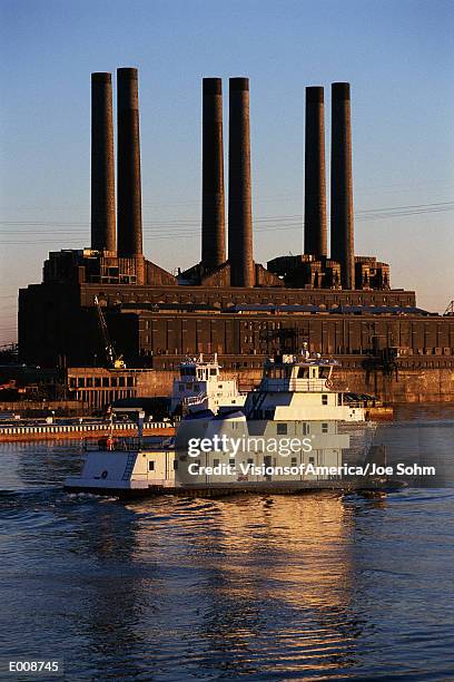 grain barge on river with factory in background - hollister stock-fotos und bilder