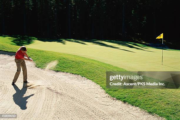 golfer in sand trap, hole marker beyond - amateur golfer stock pictures, royalty-free photos & images