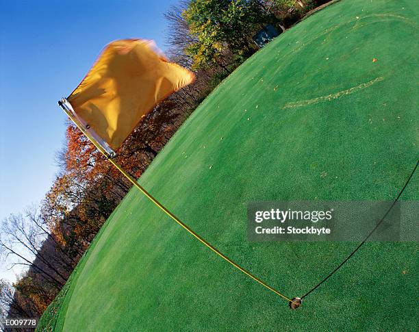 flag on golf course waving in wind - waving-sports-flag stock pictures, royalty-free photos & images